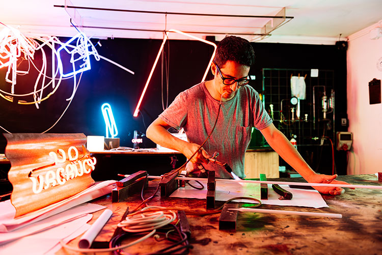 young adult working on a neon sign in a workshop 2024 06 21 21 28 59 utc